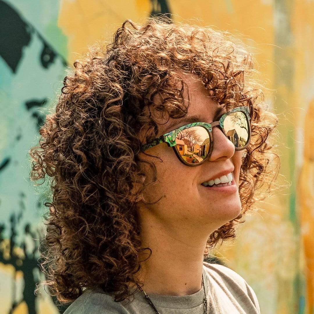 Model With Curly Hair Is Wearing Beachcomber Abalone Seashell Wooden Sunglasses With Rose Lenses