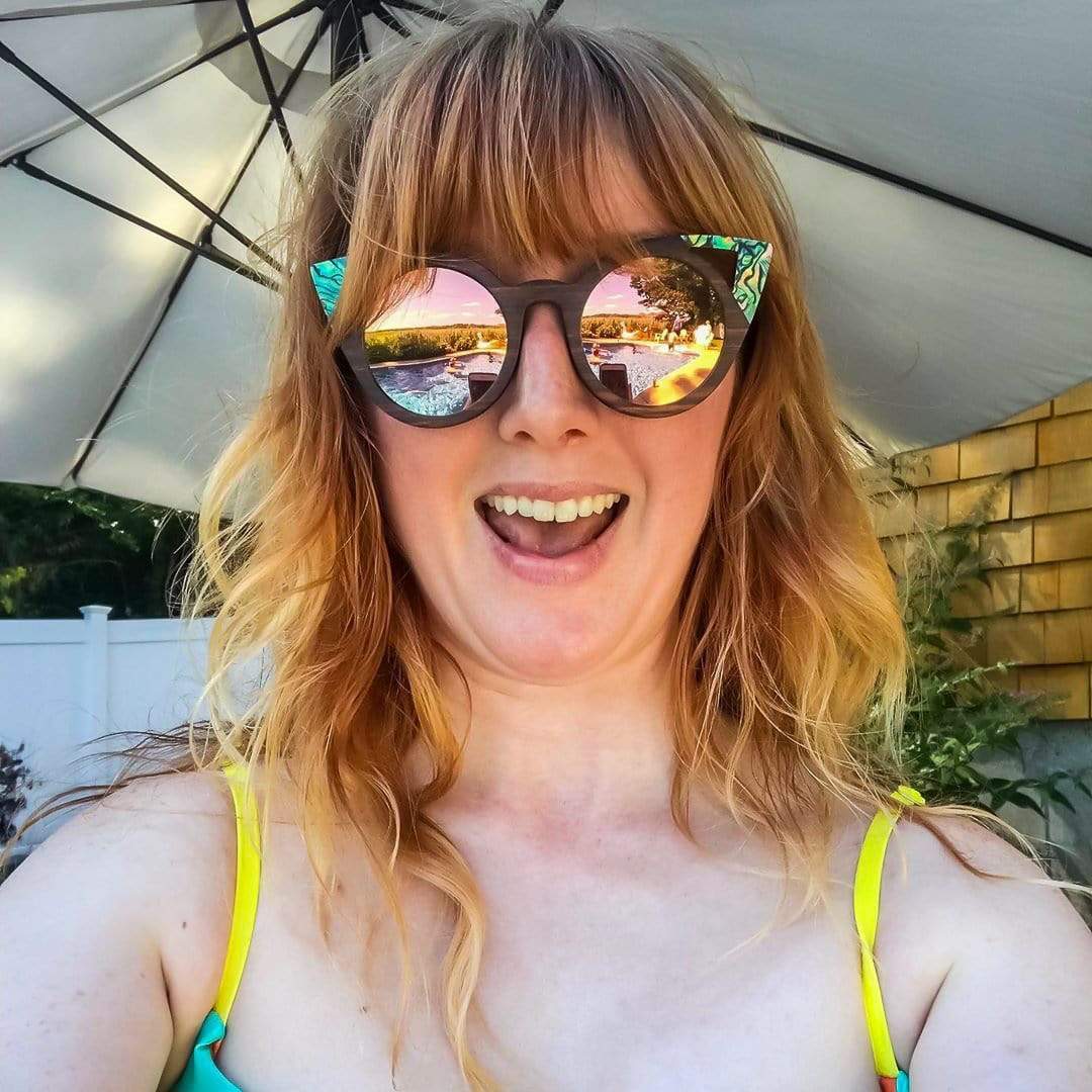 Model Wearing Cateye Sunglasses In Ebony Wood And Abalone Seashells With Rose Lenses