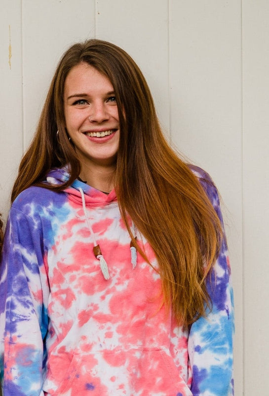 One laughing model wearing a CloudBlend Hoodie in front of a white wall