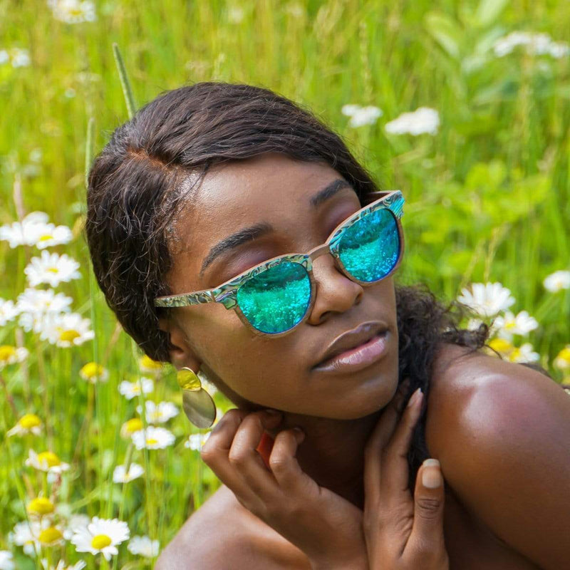 Model Wearing Beachcomber Ice Blue Wooden Abalone Sunglasses In The Meadow