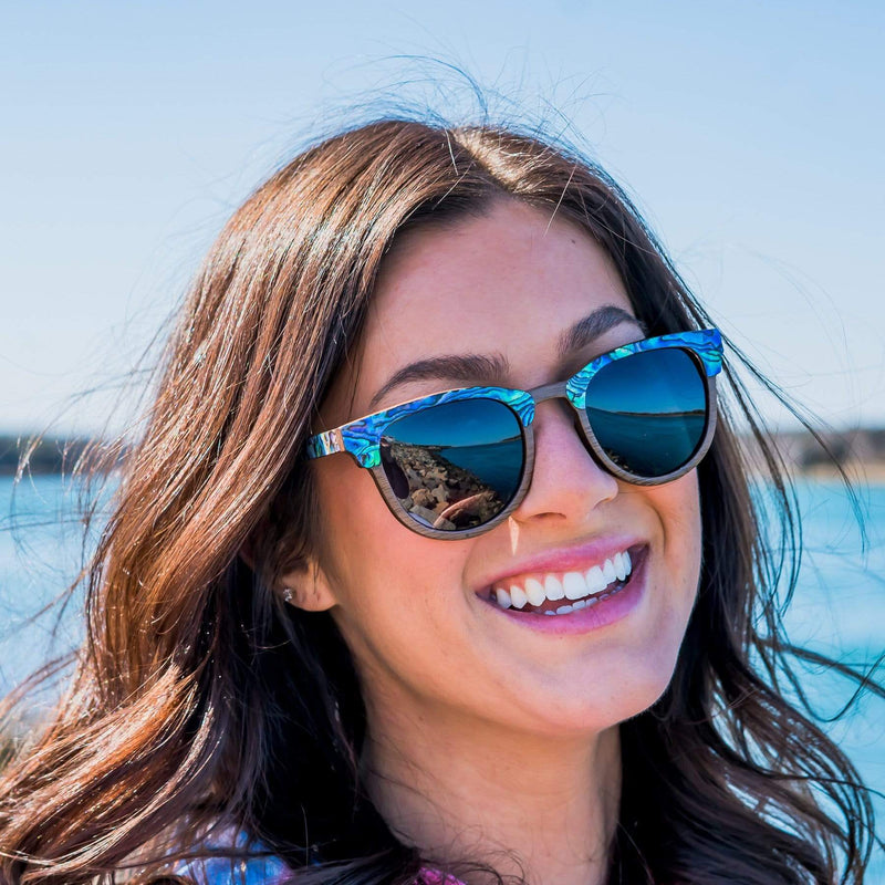 Smiling Women Wearing Wooden Sunglasses In Abalone Beachcomber Style With Smoke Lenses