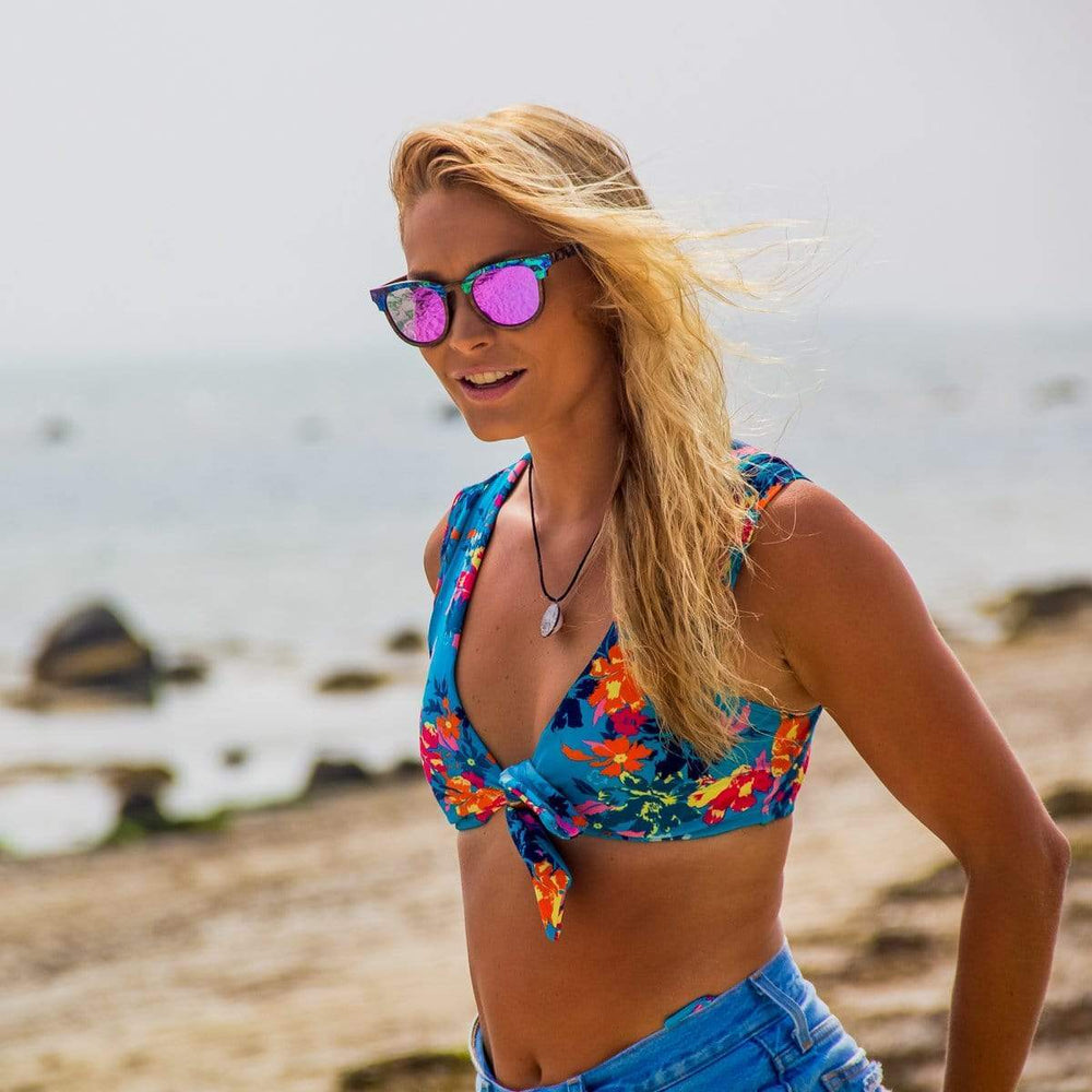 Model In Bikini Wearing Wooden Beachcomber Abalone Seashell Sunglasses With Violet Lenses At The Beach