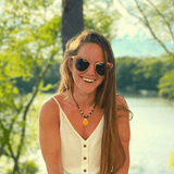 Model Wearing Wooden Bombshell Sunglasses With Smoke Lenses At A Lake 
