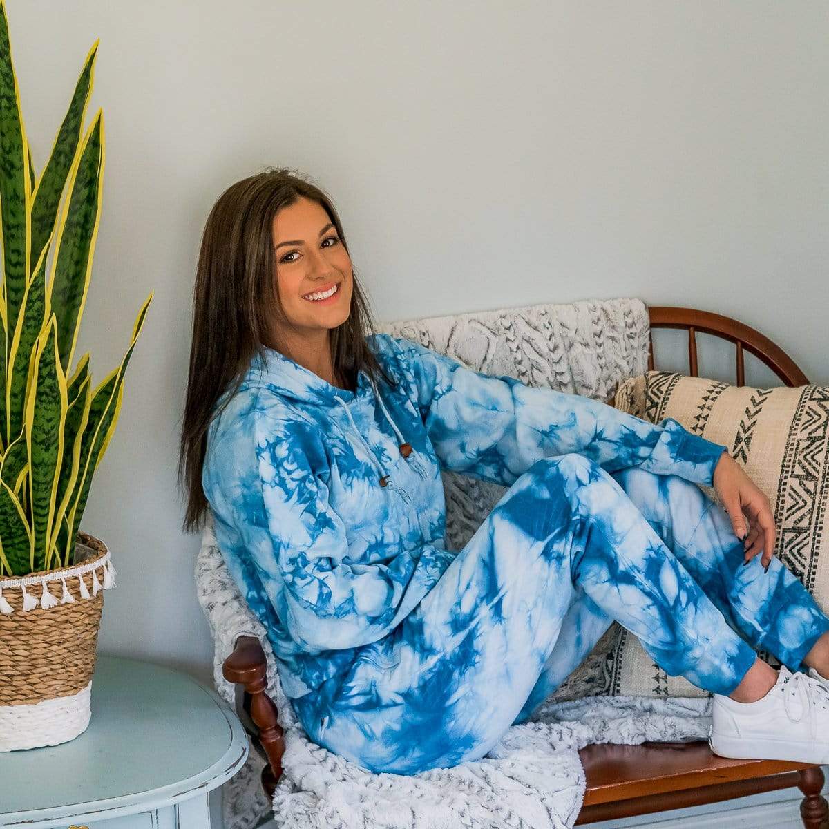 Female Model On A Sofa Wearing A Blue Marble Cloud Blend Hoodie From SLYK 