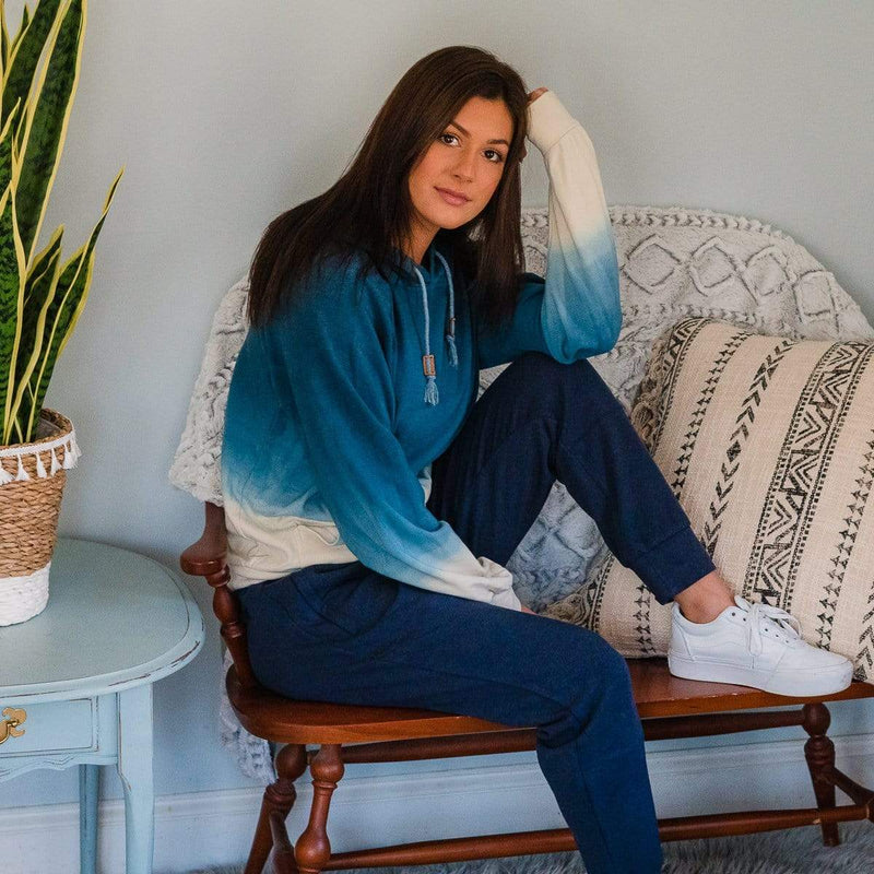 Female Model On A Sofa Wearing An Ocean Ombre Cloud Blend Hoodie From SLYK