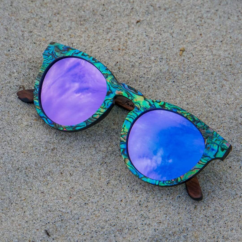 Mermaid Wooden Sunglasses With Abalone Seashell and Violet Lenses From SLYK Photographed In Sand
